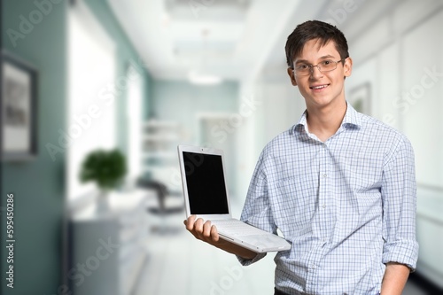 Positive young student hold laptop
