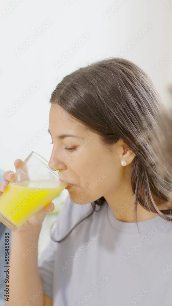 Woman drinking natural orange juice at home Woman drinking natural orange juice at home