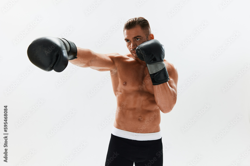 Man athletic bodybuilder poses in boxing gloves with nude torso abs in full-length background, boxing and martial arts. Advertising, sports, active lifestyle, light, competition, challenge concept. Man athletic bodybuilder poses in boxing gloves with nude torso abs in full-length background, boxing and martial arts. Advertising, sports, active lifestyle, light, competition, challenge concept.