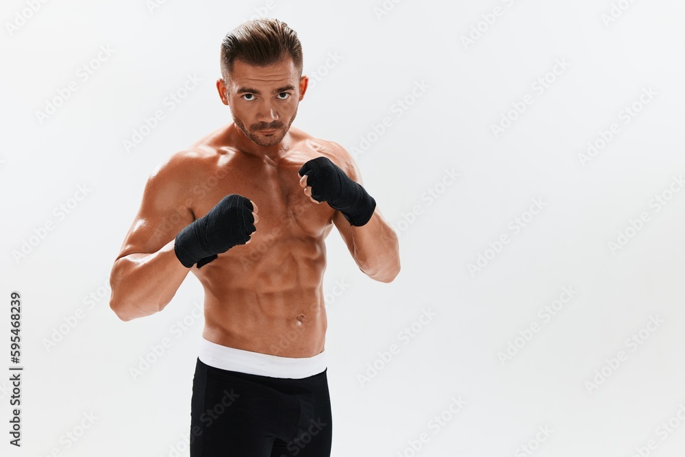 Man athletic bodybuilder poses in boxing gloves with nude torso abs in full-length background, boxing and martial arts. Advertising, sports, active lifestyle, competition, challenge concept. Man athletic bodybuilder poses in boxing gloves with nude torso abs in full-length background, boxing and martial arts. Advertising, sports, active lifestyle, competition, challenge concept.
