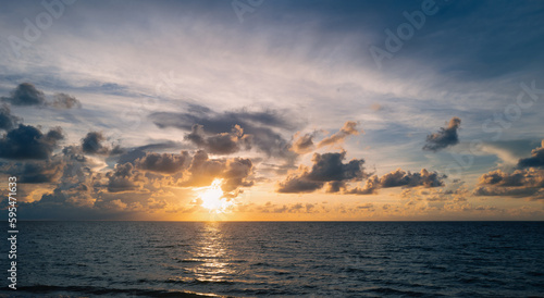 Fototapeta Naklejka Na Ścianę i Meble -  Sunset sea landscape. Colorful beach sunrise with calm waves. Nature sea sky. Colorful ocean beach sunrise with deep blue sky and sunrays. Sunrise with clouds of different colors.