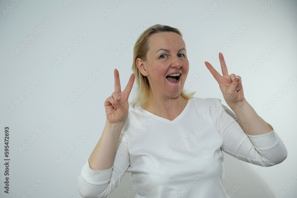 Beautiful brunette young woman wearing casual white sweater and glasses looking surprised and shocked doing ok approval symbol with fingers. crazy expression . High quality photo Beautiful brunette young woman wearing casual white sweater and glasses looking surprised and shocked doing ok approval symbol with fingers. crazy expression . High quality photo