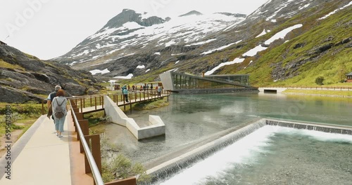 Trollstigen, Andalsnes, Norway. People Tourists Walking Visiting Viewing Platform Near Visitor Centre. Norwegian County Road 63. Concept Advertisement Of Active Life. Slow Mo, Slo Motion. photo