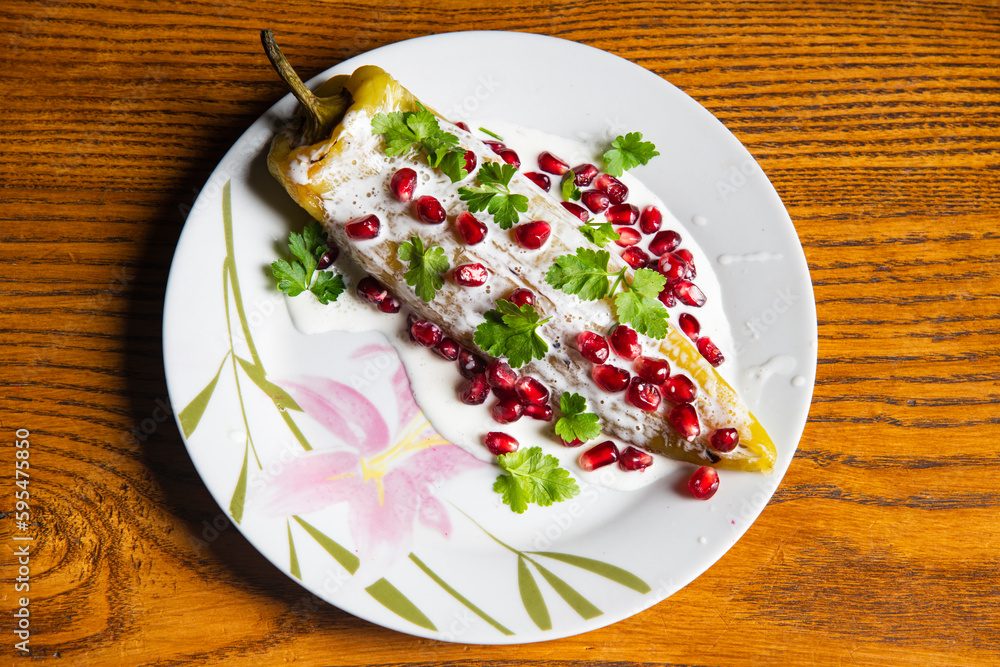 Pomegranate and Chiles en nogada dish on wooden background... Pomegranate and Chiles en nogada dish on wooden background...