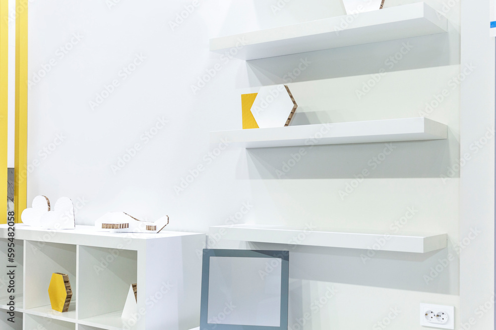 White open shelves with cabinets on a white wall. Modern minimalism in the interior. Side view. White open shelves with cabinets on a white wall. Modern minimalism in the interior. Side view.