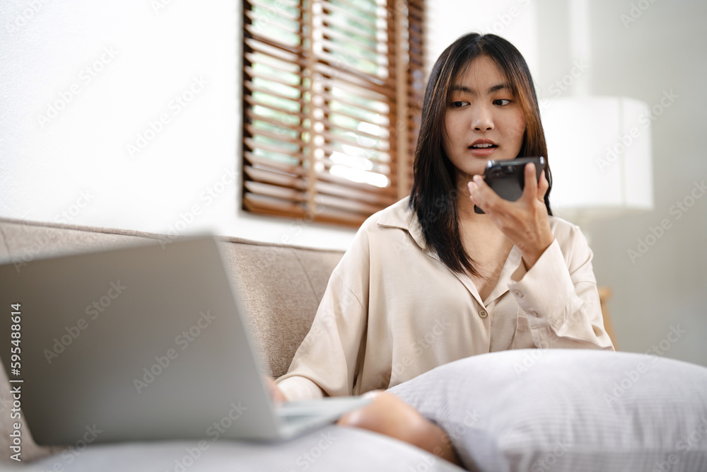 Asian girl using cell phone for checking social media at home holding smartphone in morning. Asian girl using cell phone for checking social media at home holding smartphone in morning.