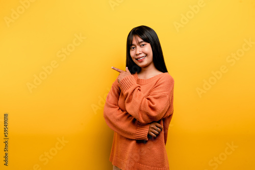 Cute Asian girl smiling on yellow background. Empty, young woman. Place for advertisement. copy space © FOTO SALE