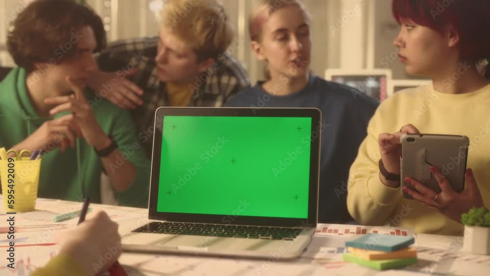 A young group of managers or startups are discussing a new project. Laptop with green screen. Youth group of men and women work in the office. Advertising area, workspace mock up. A young group of managers or startups are discussing a new project. Laptop with green screen. Youth group of men and women work in the office. Advertising area, workspace mock up.