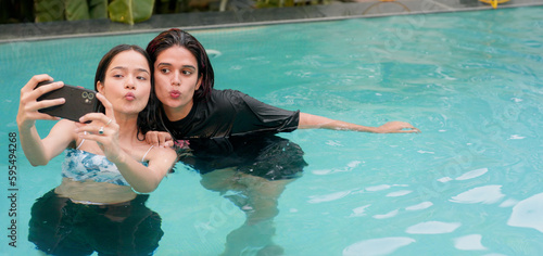 Photography Indian Hindu smiling young women standing water pool hold mobile take funny self