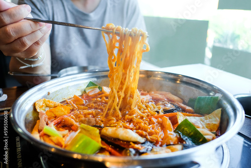 Hot pot of budae jjigae, korean instant noodles (ramyeon), pork,  sausage, mussels and vegetables, delicious Korean food.