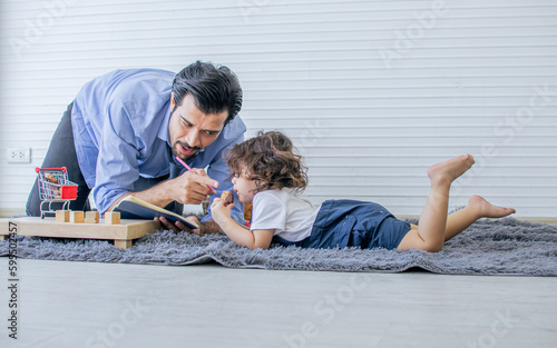 Caucasian handsome father playing toys with his little cute daughter at home after work. Family and Education Concept.