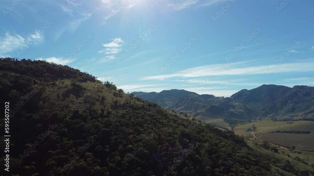 Foto de paisagem com colinas montanhas céu azul e floresta com drone