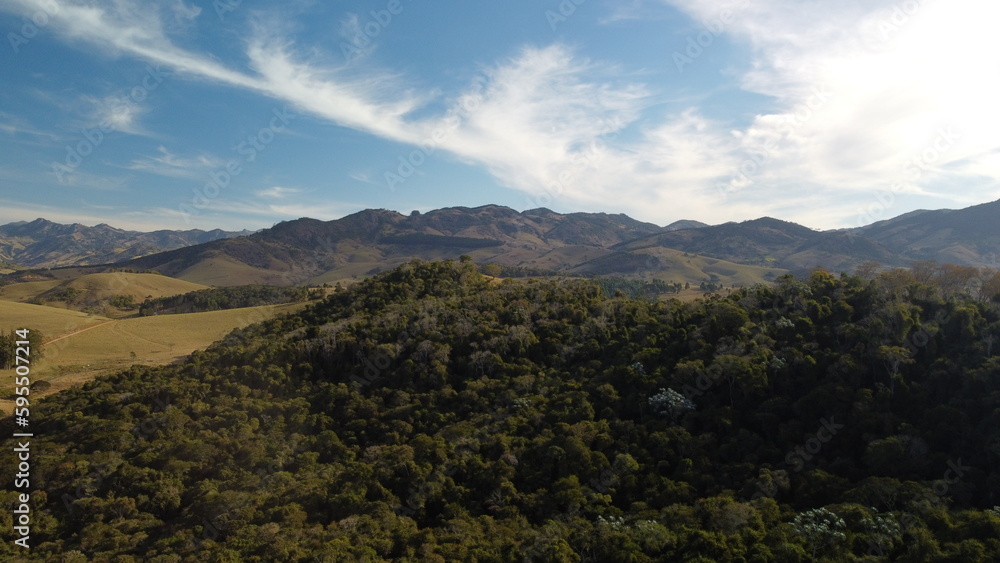 Foto de paisagem com colinas montanhas céu azul e floresta com drone