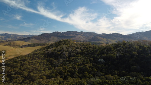 Foto de paisagem com colinas montanhas céu azul e floresta com drone