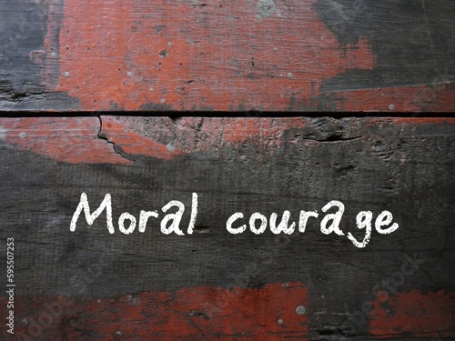 Grunge vintage wall with handwritten text MORAL COURAGE, means courage to take action for moral reasons or act upon ethical values to help others during difficult ethical dilemmas photo