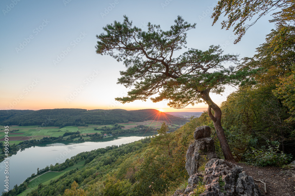 Sonnenuntergang auf einem Berg mit Fels und Baum und Blick auf einen See in Franken. Sonnenuntergang auf einem Berg mit Fels und Baum und Blick auf einen See in Franken.
