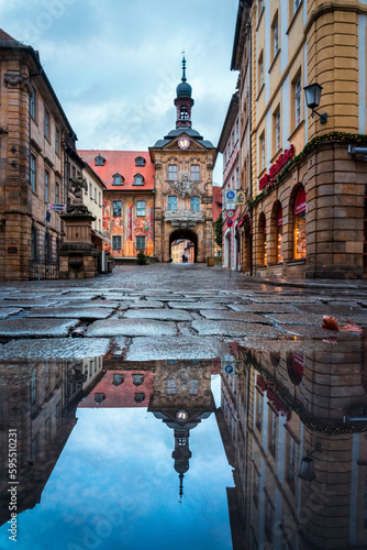 Spiegelung von alter Architektur in Bamberg in einer Pfütze im Kopfsteinpflaster.