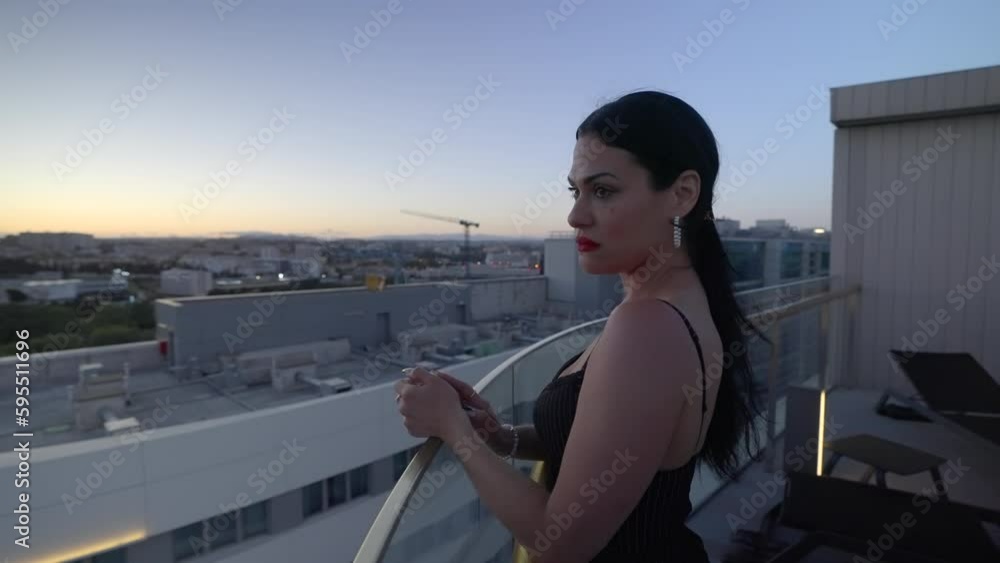 Attractive Sad Woman next to infinity pool looking over cityscape during sunset Attractive Sad Woman next to infinity pool looking over cityscape during sunset