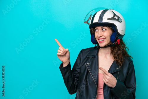 Young caucasian woman with a motorcycle helmet isolated on blue background intending to realizes the solution while lifting a finger up © luismolinero