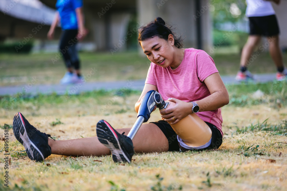 Athlete with prosthetic leg doing warm up exercise on park. Woman wearing prosthetic equipment for jogging. Female with prosthesis of leg Athlete with prosthetic leg doing warm up exercise on park. Woman wearing prosthetic equipment for jogging. Female with prosthesis of leg