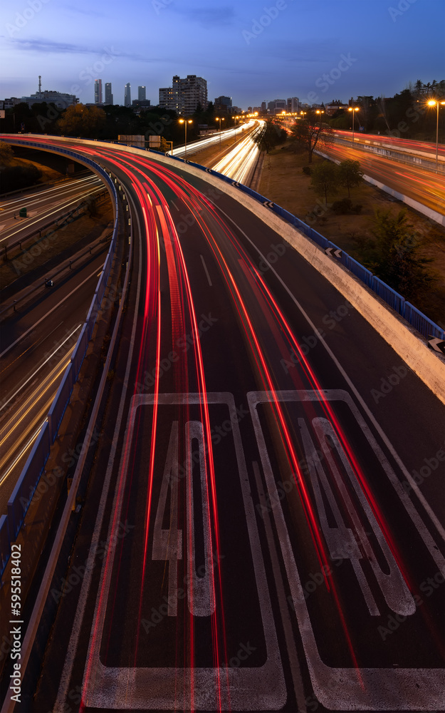 Slow down sign on the highway when entering the city,Slow down sign on the highway when entering the city, car light trails Slow down sign on the highway when entering the city,Slow down sign on the highway when entering the city, car light trails