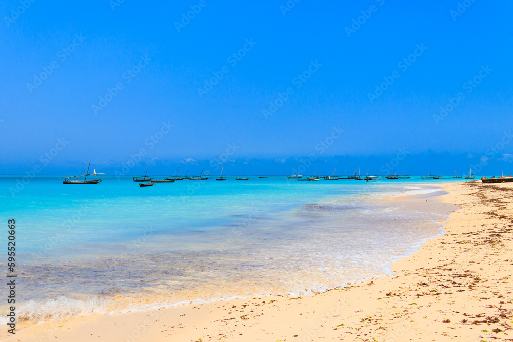 View of tropical sandy Nungwi beach and traditional wooden dhow boats in the Indian ocean on Zanzibar, Tanzania