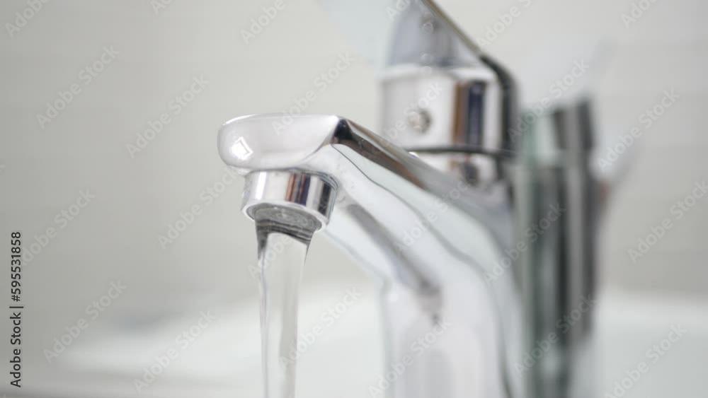 Hand Turn Off the Tap Water on Sink, Faucet, Woman Stops Wasting Water, Inundation, Running Water for Washing in Bathroom Hand Turn Off the Tap Water on Sink, Faucet, Woman Stops Wasting Water, Inundation, Running Water for Washing in Bathroom