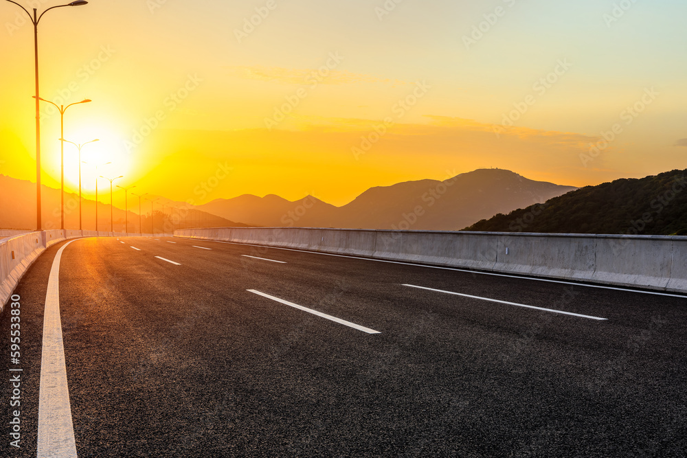 Asphalt road and mountain natural background at sunset