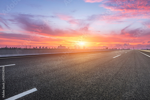 Asphalt road and skyline with sky clouds at sunrise