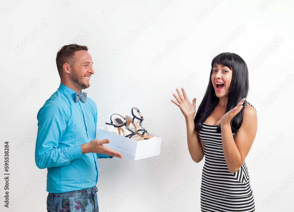 The guy shows the young girl the shoes in the box. The guy shows the young girl the shoes in the box.