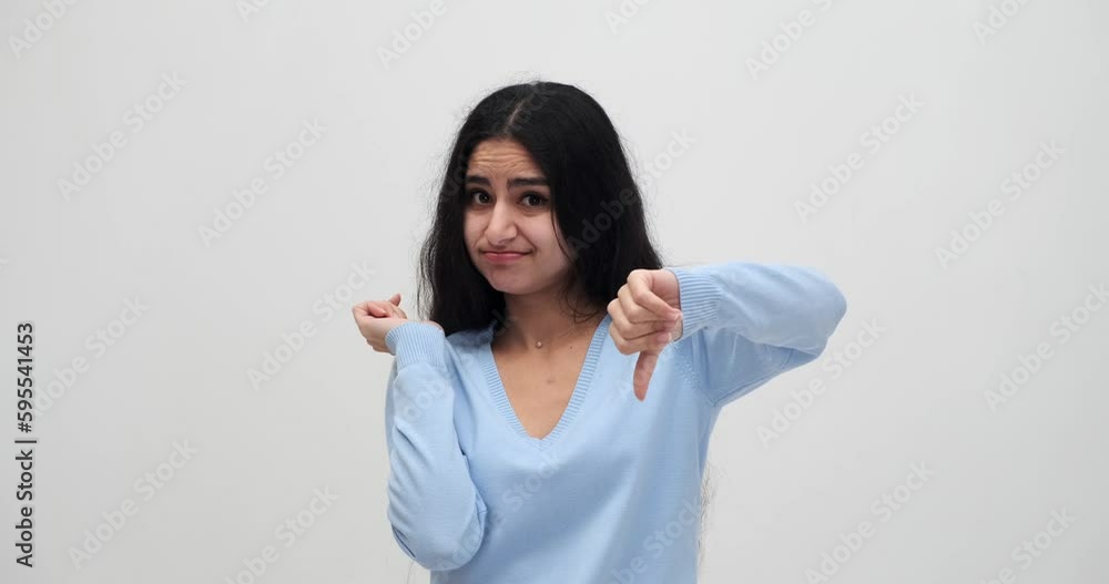 Portrait of woman regretting her deeds and giving thumbs down gesture Portrait of woman regretting her deeds and giving thumbs down gesture