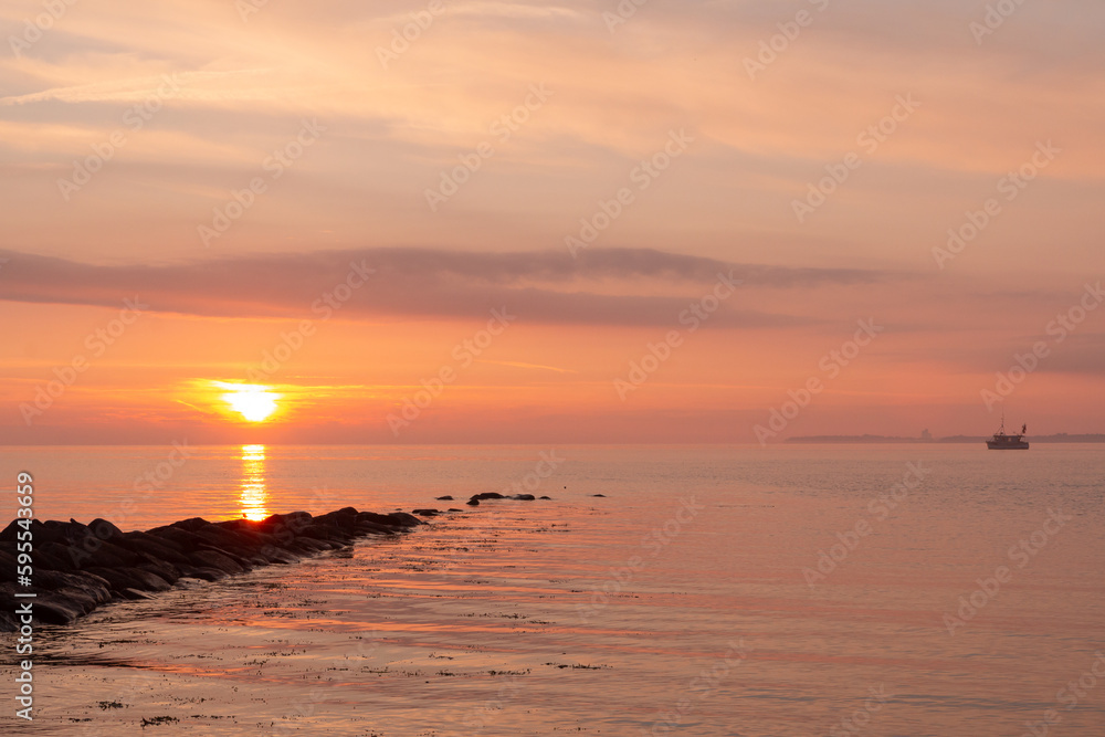 kleines Fischerboot bei Sonnenaufgang an der Ostsee.