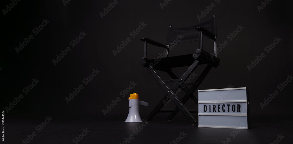 Black director chair and light box and megaphone on black background.