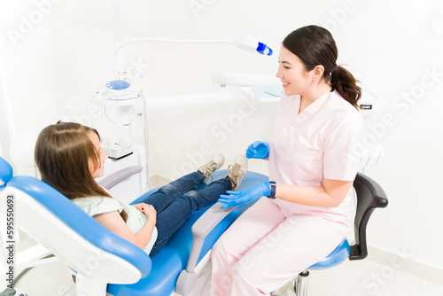 Beautiful pediatric dentist treating a little girl patient