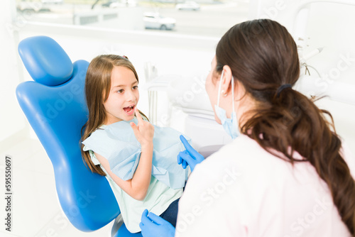 Cheerful kid patient talking to the pediatric dentist