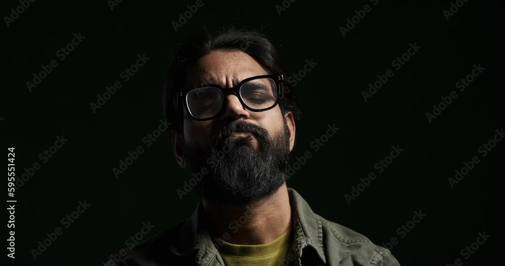 Closeup portrait of stressed bearded young man taking deep breath and shaking head isolated against black background Closeup portrait of stressed bearded young man taking deep breath and shaking head isolated against black background