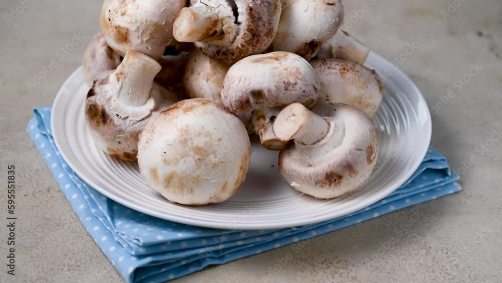 Raw champignon mushrooms on spinning plate. Fresh vegetables for cooking. Raw champignon mushrooms on spinning plate. Fresh vegetables for cooking.