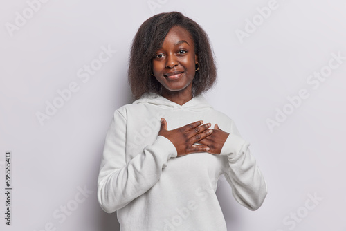 Photography Lovely dark skinned Afro American woman being honest presses hands to heart touc