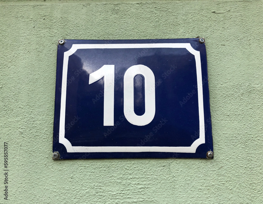 The number ten sign on a green wall The number ten sign on a green wall