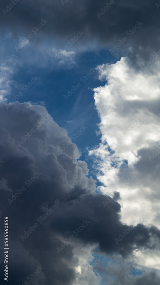 Two big fluffy clouds. Clear sky between two big clouds. Big white clouds meet each other Two big fluffy clouds. Clear sky between two big clouds. Big white clouds meet each other