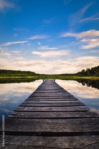 Fototapeta Naklejka Na Ścianę i Meble -  Beautiful summer afternoon landscape by the lake. Charming wooden pier over a small lake in Michala Gora, Poland.