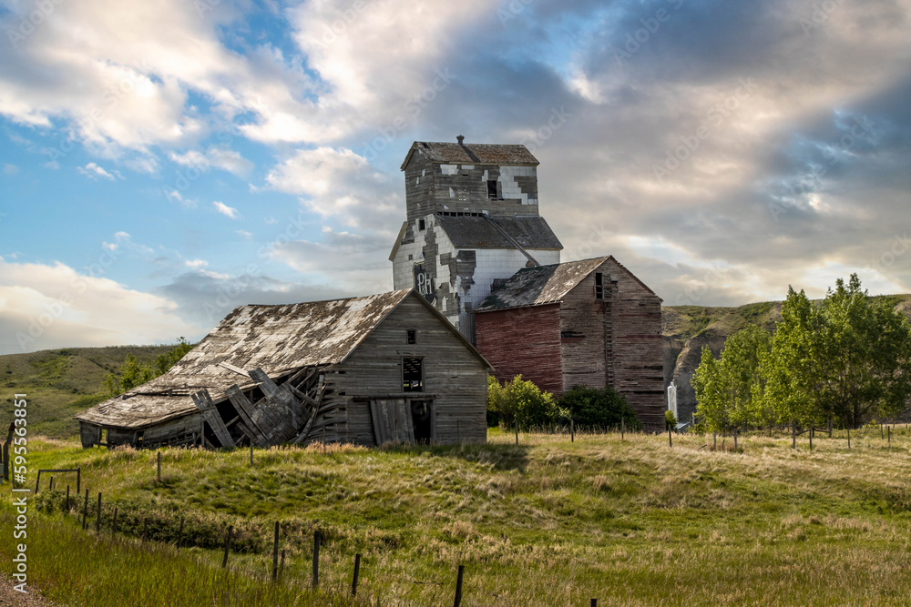 Obraz premium Rustic buildings and grain elevator stand in what used to be the town of Sharples Alberta Canada