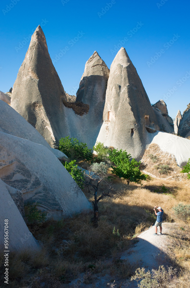 Fairy Chimneys rock formation in Cappadocia, Tourist taking photo of ...