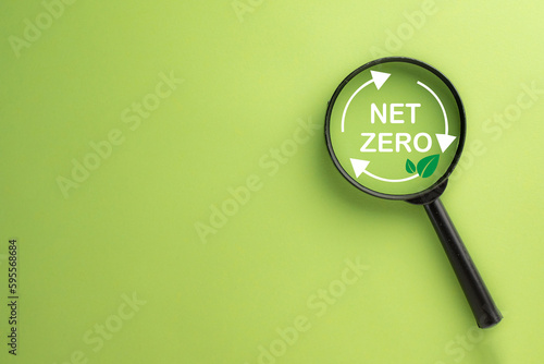 Net zero,Reduce CO2 emission concept.,Magnifying glass focus on Net zero icon over green background with copyspace use for Net Zero 2050 Carbon Neutral idea.