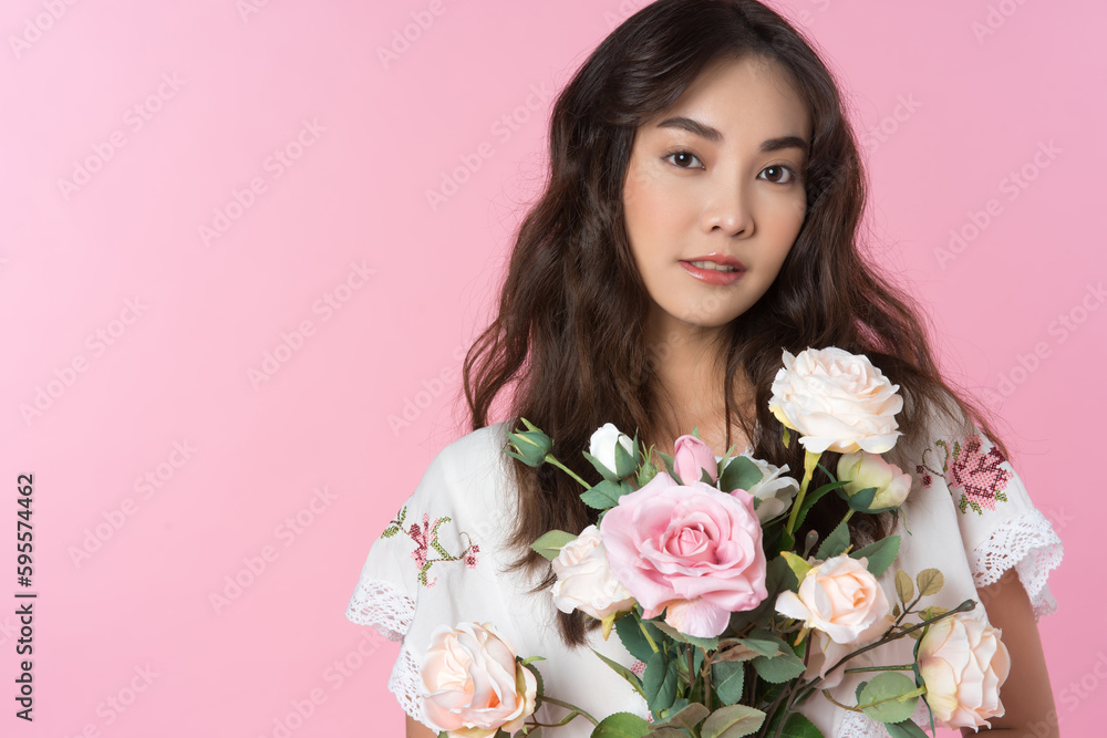 Young Asian woman holding a rose bouquet on hand isolated pink color background Young Asian woman holding a rose bouquet on hand isolated pink color background