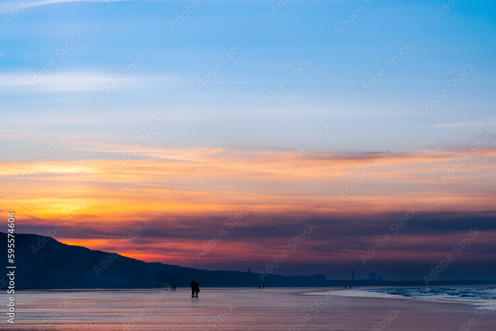 Sunset Sky with clouds over sea sand beach with ocean wave in evening Summer,Landscape by Seaside with Colourful Sky in Orange,Pink,Purple,Blue.Beautiful Horizontal Sunlight reflection on sandy beach