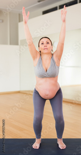 Pregnant woman is engaged in yoga. Chair Pose or Utkaasana
