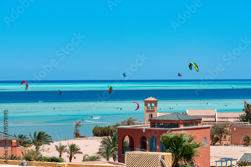 Kitesurfer und Foiler vor der Skyline (Stadtkulisse) von El Gouna, Ägypten und den Red Sea Mountains im Hintergrund