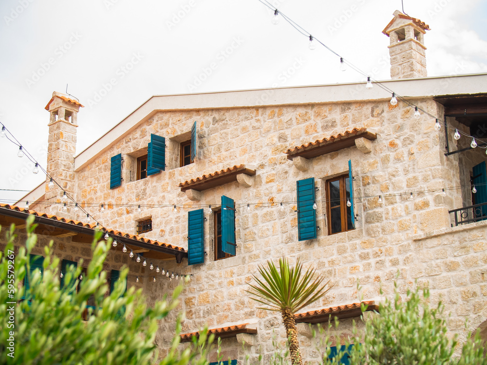 Residential house facade with blue traditional window shutters in urban scene - mediterranean old-fashioned architecture