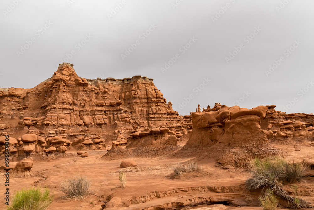 Scenic view on unique eroded sandstone hoodoo rock formations at Goblin Valley State Park, Utah, USA, America. Orange rocks called goblins which are mushroom-shaped rock pinnacles. Massive cliff Scenic view on unique eroded sandstone hoodoo rock formations at Goblin Valley State Park, Utah, USA, America. Orange rocks called goblins which are mushroom-shaped rock pinnacles. Massive cliff